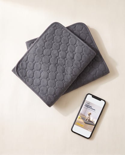 Kit Duo StayMat: due tappetini lavabili piegati e la guida «7 giorni per insegnare il posto» sul telefono